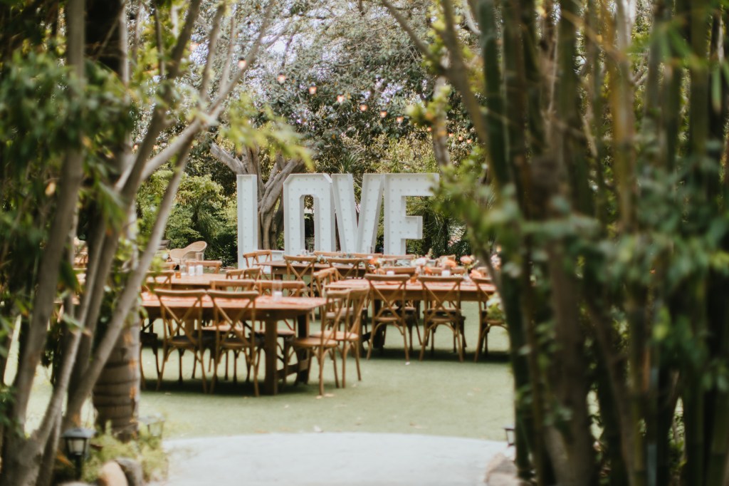 tropical garden wedding reception with large LOVE sign